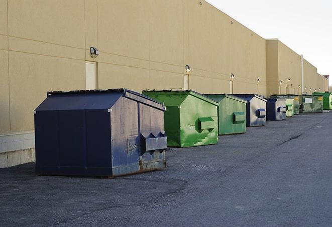 a fleet of red and blue construction dumpsters available for use in Houma